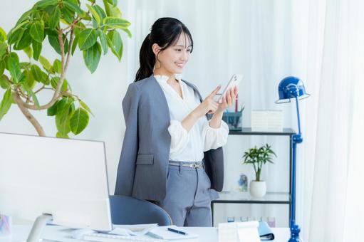 スマホを操作するビジネスウーマン ビジネスウーマン,スマホ,笑顔の写真素材