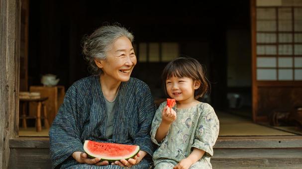 縁側でスイカを食べながら笑う祖母と孫 縁側でスイカを食べながら笑う祖母と孫の写真