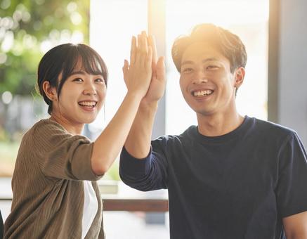 ハイタッチする若い男女 ハイタッチする若い男女の写真