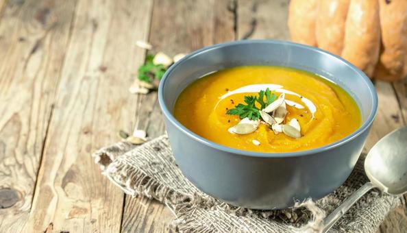 温かいかぼちゃスープと秋の食卓風景の写真
