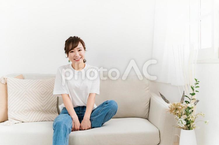 家のソファに座る笑顔の日本人女性 女性,笑顔,ソファの写真素材