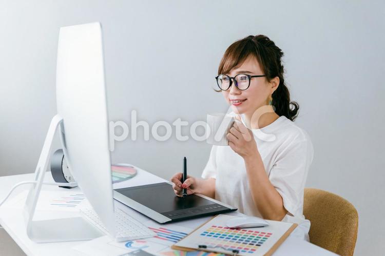 ペンタブで絵を描く制作会社の日本人女性 制作会社,ペンタブ,デザイナーの写真素材
