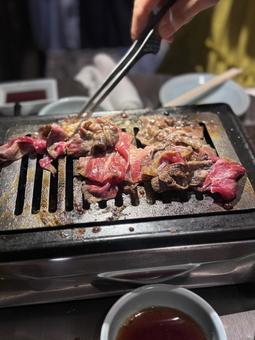 焼肉を焼く手 焼肉を焼く手の写真