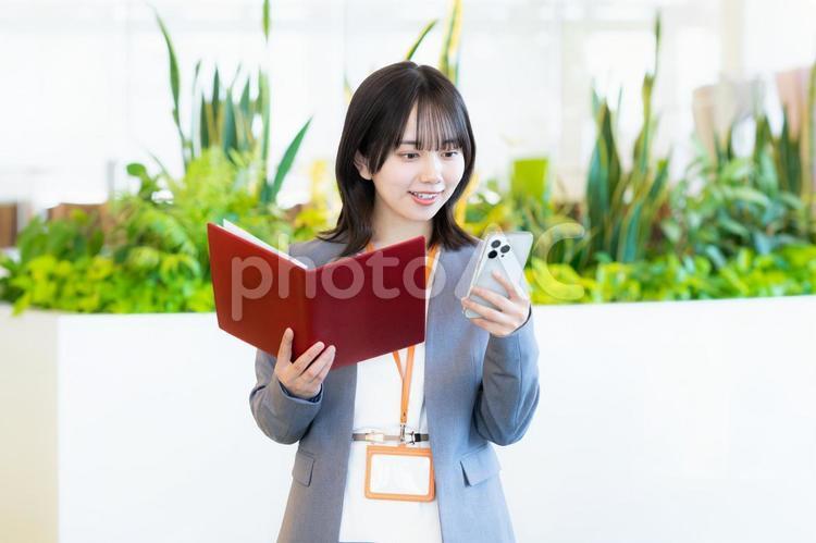 スマホを操作するビジネスウーマン ビジネスウーマン,スマホ,笑顔の写真素材