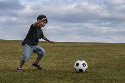 ＜素材＞山頂で元気にサッカーをする男の子 子供,サッカー,運動の写真素材