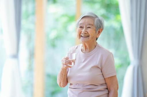 水の入ったコップを持つ笑顔の女性 女性,コップ,水の写真素材