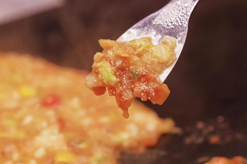 鉄板でもんじゃ焼きを調理する様子 もんじゃ焼き,もんじゃ,鉄板焼きの写真素材