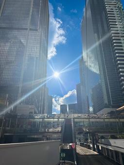 青空と太陽が輝く高層ビル街の都市風景 青空と太陽が輝く高層ビル街の都市風景の写真