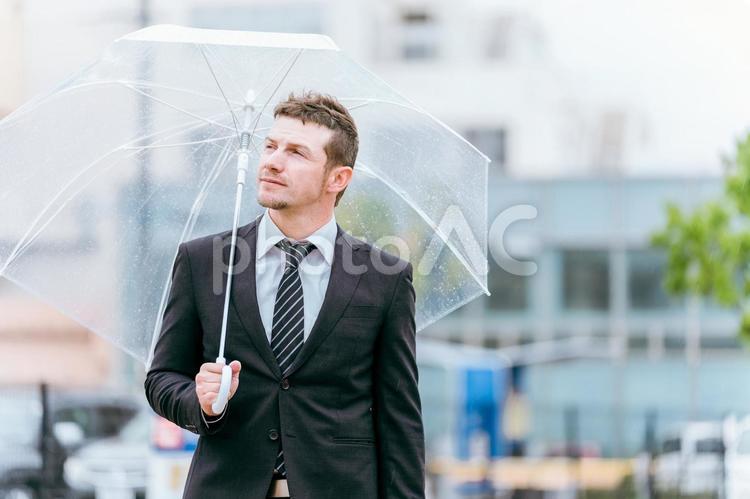 梅雨・台風の雨で傘をさすビジネスマン 雨,傘,ビジネスマンの写真素材