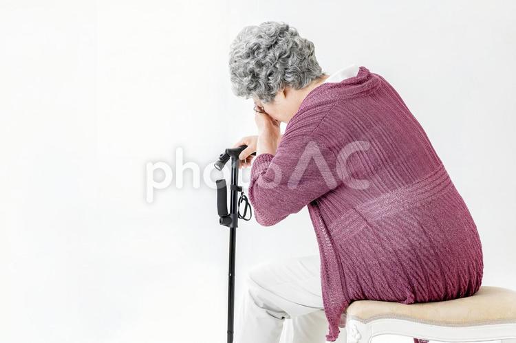 杖をついて苦しむ高齢者の女性 高齢者,頭痛,頭の写真素材