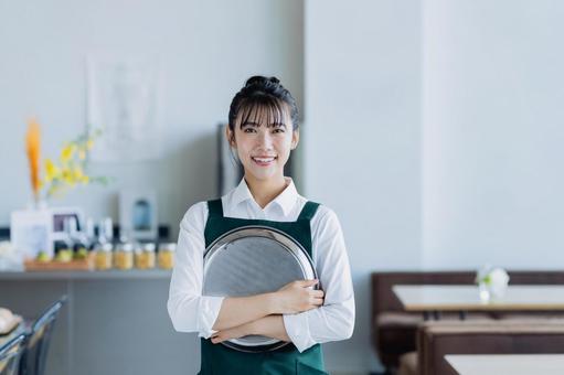 カフェで働く若い女性 カフェで働く若い女性の写真