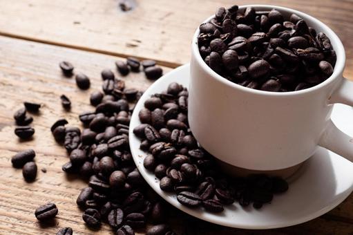 コーヒーカップに入れたコーヒー豆 コーヒーカップに入れたコーヒー豆の写真