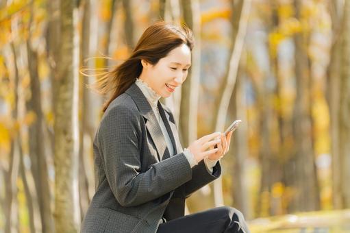 紅葉の街路樹と女性・ビジネスウーマン 女性,秋,紅葉の写真素材