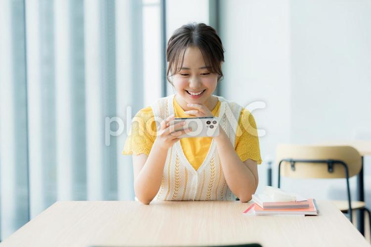 カフェでスマホを見る学生 スマホ,若い,若い女性の写真素材