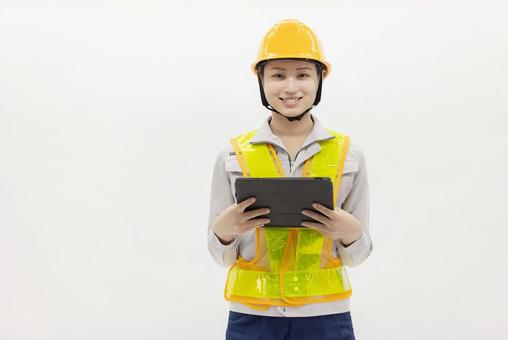 タブレットを使う作業服の女性 タブレットを使う作業服の女性 女性,作業員,指差しの写真素材