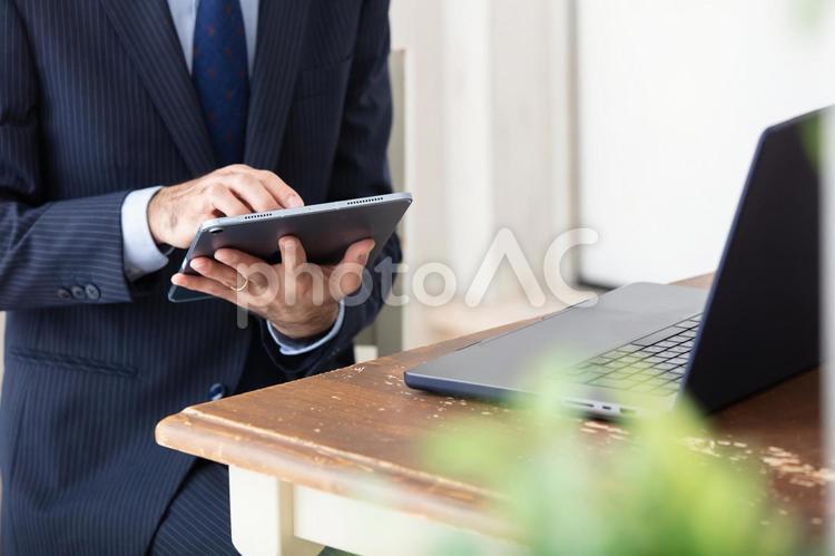 タブレット操作する男性の手元　 男性,タブレット,ビジネスの写真素材