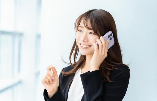 スマホで話す笑顔の女性・ビジネスウーマン スマホで話す笑顔の女性・ビジネスウーマン 女性,スマホ,スマートフォンの写真素材
