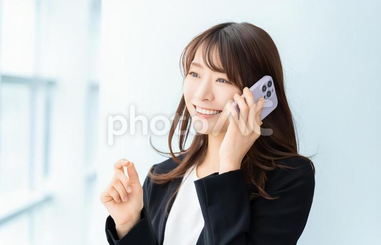 スマホで話す笑顔の女性・ビジネスウーマン 女性,スマホ,スマートフォンの写真素材