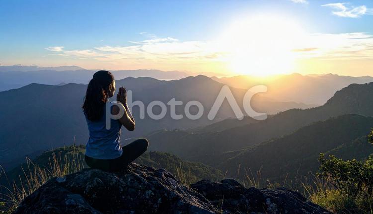 夕焼けに手を合わせて祈る女性 祈り,瞑想,女性の写真素材