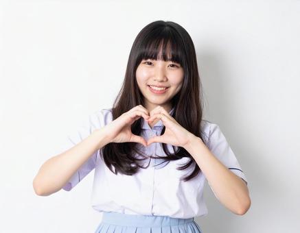 手でハートマークを作る女子生徒の写真
