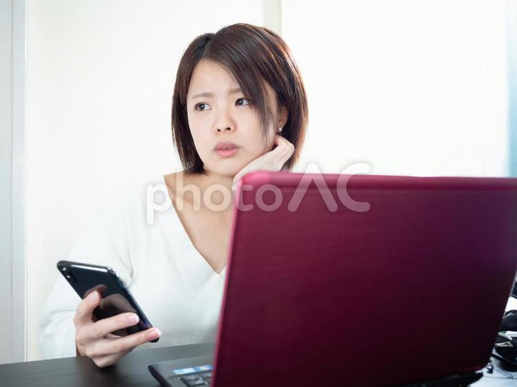 【女性】在宅勤務中、PC操作する女性（スマホ） ol,オフィスレディ,女性の写真素材