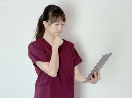 タブレットを持つ看護師(医療従事者) 考える,検討,診療結果の写真素材