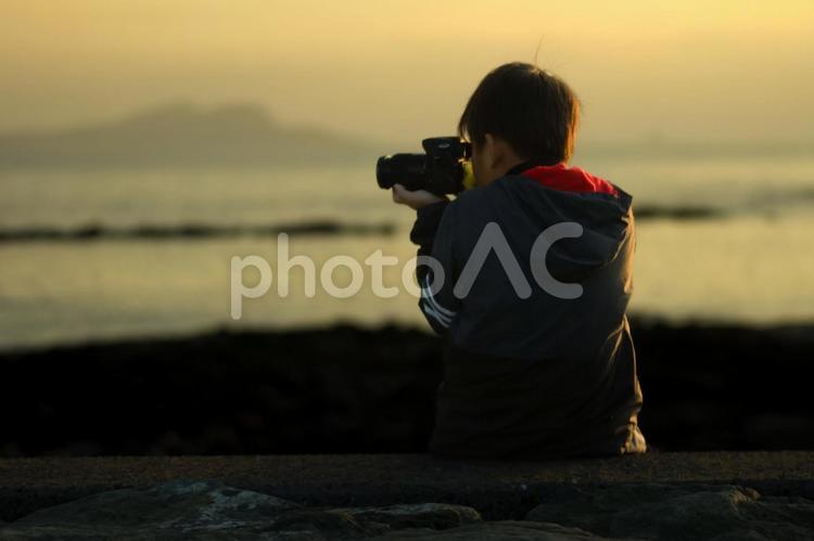 R＜素材＞家族旅行で夜明けの海を撮る少年 子供,海,写真の写真素材