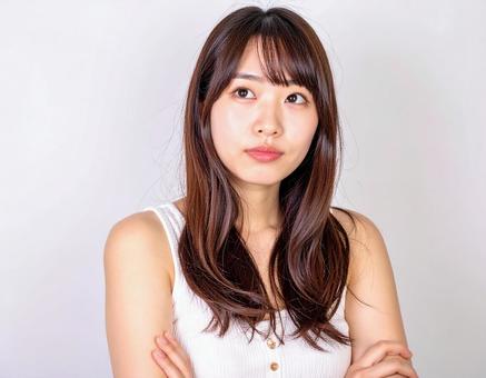 腕を組んで悩んでいる女性 腕を組んで悩んでいる女性の写真