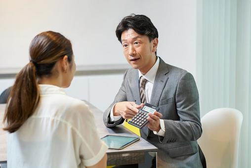 女性に向かって話すスーツ姿の男性 女性に向かって話すスーツ姿の男性 営業,男性,保険の写真素材