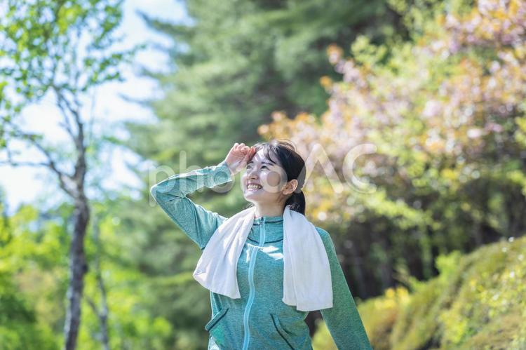 緑の中でウォーキングする女性（汗） 新陳代謝,運動,汗の写真素材