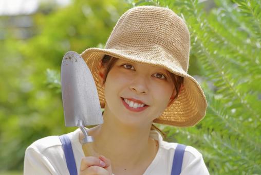 スコップで庭いじりをしている女性 スコップで庭いじりをしている女性 ガーデニング,園芸,庭づくりの写真素材