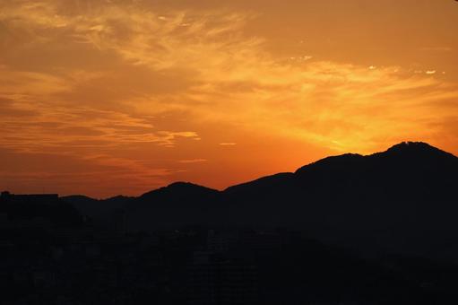 シルエットの山とオレンジ色の夕空の風景の写真