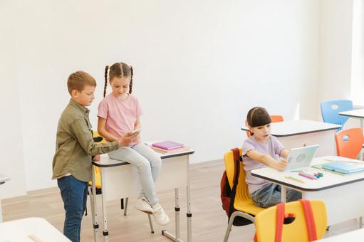 携帯とタブレットタブレットを見ている生徒たち 男の子,女の子,子どもの写真素材