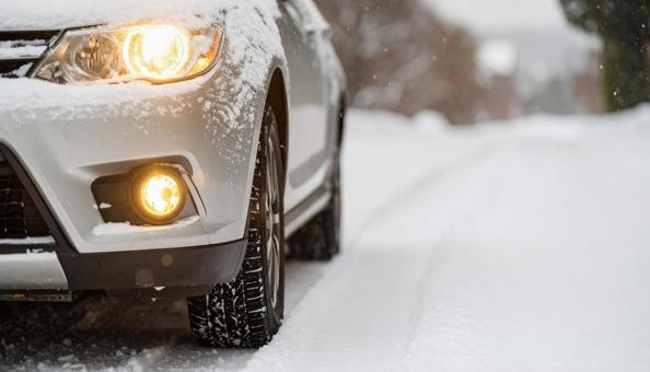 大雪が降った翌日の雪が積もった道を走る車 大雪が降った翌日の雪が積もった道を走る車の写真