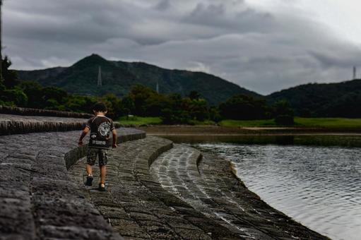 素材>雨上がりの海辺を散歩する男の子” 素材>雨上がりの海辺を散歩する男の子” 子供,海,歩くの写真素材