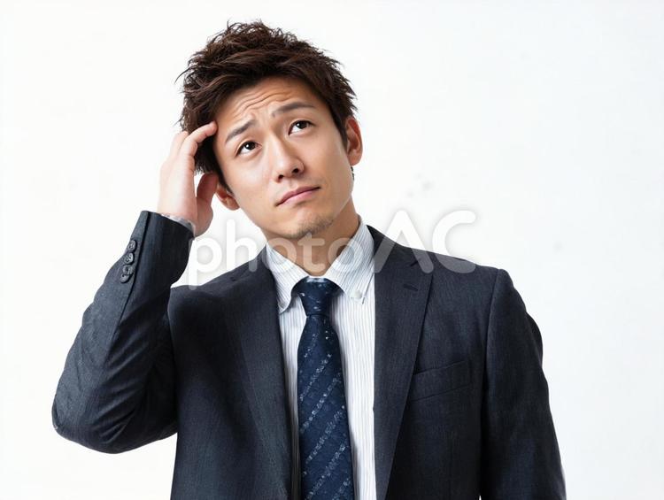 頭を押さえて考えるビジネスマン 男性,悩む,考えるの写真素材