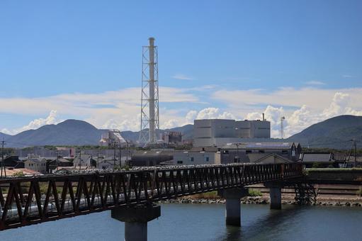 橋と川と煙突の工場のある町と山と雲と青空 橋,川,煙突の写真素材