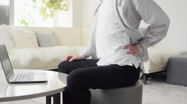 パソコン作業で腰が痛くなるアジア人男性 パソコン作業で腰が痛くなるアジア人男性 タイピング,腰,痛いの写真素材