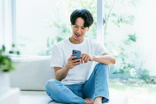 スマホを操作する男性 スマホを操作する男性 スマホ,笑顔,男性の写真素材