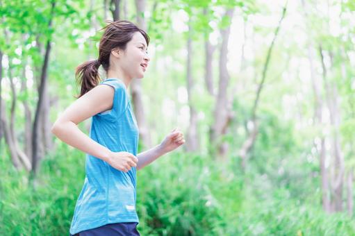 自然の中でランニングをする若い女性 自然の中でランニングをする若い女性の写真