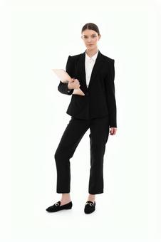 パソコンを持ちポーズするスーツ女性 パソコンを持ちポーズするスーツ女性 女性,ノートパソコン,持つの写真素材