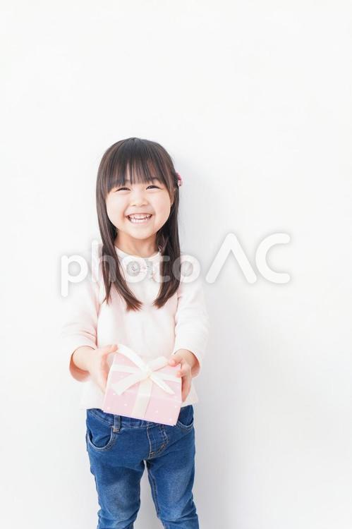 笑顔でプレゼントを渡す女の子 誕生日,チョコレート,保育所の写真素材