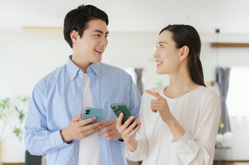 スマホを持って会話する若いカップル 夫婦,カップル,会話の写真素材