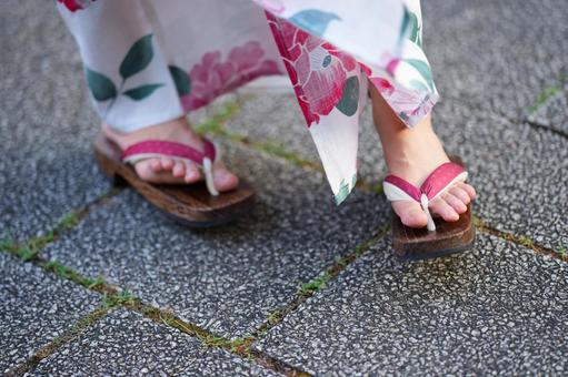 浴衣姿の女性の足元と下駄の写真