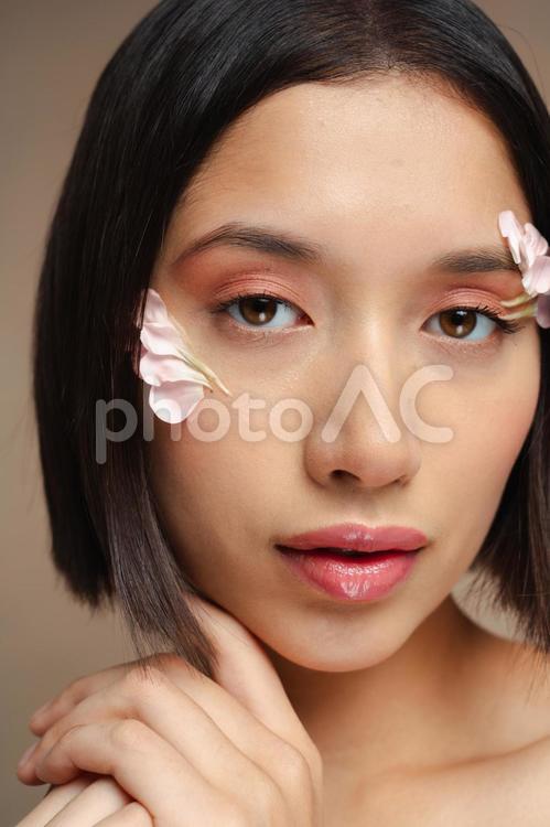 目尻に花びらを付けた女性のアップ 女性,フラワーメイク,花びらの写真素材