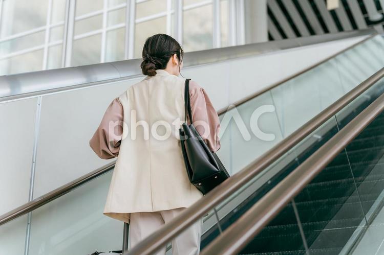 空港・駅のエスカレーターで昇る女性 出張,海外出張,ビジネスウーマンの写真素材