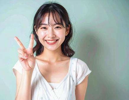 ピースサインをする笑顔の女性 ピースサインをする笑顔の女性の写真