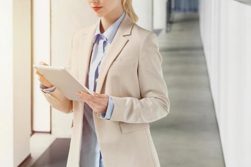 オフィスの通路でタブレットを使うビジネスウーマン ビジネスウーマン,ビジネス,女性の写真素材