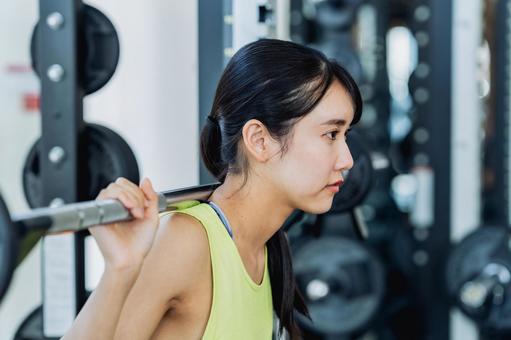 ジムでトレーニングする若い女性 ジム,バーベル,女性の写真素材