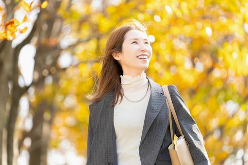 紅葉の街路樹と女性・ビジネスウーマン 女性,秋,紅葉の写真素材